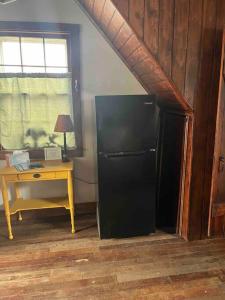 a black refrigerator in a room with a desk at Hanna’s Cottage-Downtown Hermann in Hermann