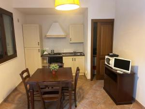 a small kitchen with a table and a microwave at Case Vacanza Santoro in Custonaci