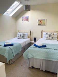 a bedroom with two beds and a skylight at ORCHARD HILL HOUSE Apartment in Paignton