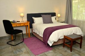 a bedroom with a bed and a desk and a chair at Altenburgh Accommodation - Apartments in Somerset East