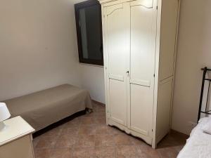 um quarto com uma cama e um armário branco em Case Vacanza Santoro em Custonaci