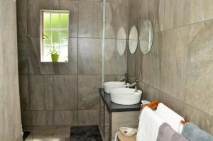 a bathroom with two sinks and a mirror at Altenburgh Accommodation - Apartments in Somerset East