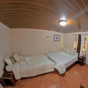 a bedroom with two beds and a ceiling at Casa Jungle Monteverde B&B in Monteverde Costa Rica