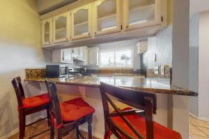 a kitchen with a counter and two chairs at a bar at Dolphin #22 in South Padre Island