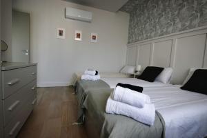 1 dormitorio con 2 camas y toallas. en Cliff Edge Apartment in Xaghra, en Taʼ Bullara