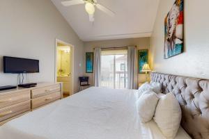 1 dormitorio con 1 cama blanca y TV en Dolphin #22, en South Padre Island