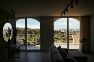 a living room with a couch and a large window at Cliff Edge Apartment in Xaghra in Taʼ Bullara