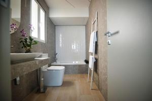 a bathroom with a sink and a toilet and a tub at Cliff Edge Apartment in Xaghra in Taʼ Bullara