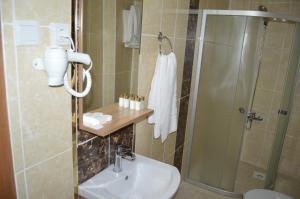 a bathroom with a shower and a sink at Vadi-i Leman Hotel in Adıyaman