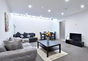 un soggiorno con divano e tavolo di Lancing Apartments - Spacious 2 Bed - Sleeps 6 - Burnham Village a Slough