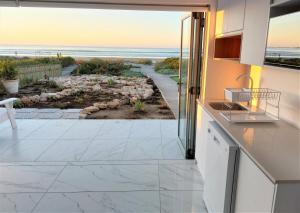 a kitchen with a view of the beach at Soli Deo Gloria, Pearl Studio - Solar in Paternoster