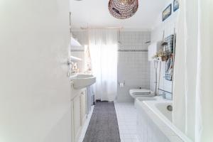 een witte badkamer met een wastafel en een toilet bij Casa Tiramisù in Bergamo