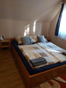 ein Schlafzimmer mit einem Bett mit zwei Handtüchern darauf in der Unterkunft Számadó Vendégház in Poroszló