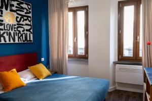 1 dormitorio con 1 cama con 2 almohadas amarillas en Room 45, en Florencia