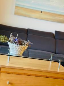 a glass coffee table with a basket of flowers on it at Apartment Wenus in Promajna