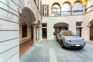 een auto geparkeerd op een binnenplaats van een gebouw bij Casa Tiramisù in Bergamo