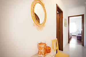 lustro na ścianie pokoju ze stołem w obiekcie Apartamento Maresia w Faro