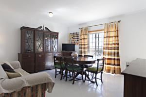 a living room with a dining room table and a couch at Apartamento Maresia in Faro