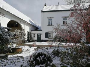 a house with snow on the ground in front of it at La Vache Contente in Maastricht