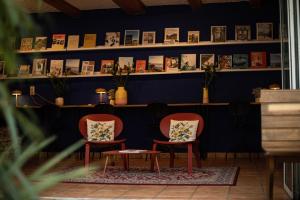 two chairs in a room with books on the wall at DAS SCHÖNE LEBEN Pop-Up Hotel in Hornberg