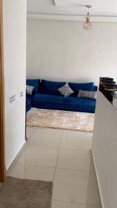 a blue couch sitting in a living room at Appartement avec piscine in Pont Blondin