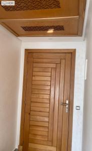 a wooden door in a room with a ceiling at Appartement avec piscine in Pont Blondin