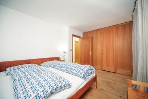 オルティゼーイにあるApartments Stinaのベッドルーム(ベッド1台、木製キャビネット付)