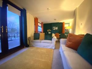 una sala de estar con 2 sofás blancos y una ventana grande en Stunning 4-bedroom Cabin with Hot Tub in Beattock! en Beattock