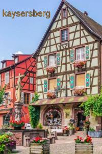 un grand bâtiment avec des fleurs devant lui dans l'établissement O P'tit Bawala, à Beblenheim