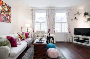 a living room with a couch and a tv at Stylish room with private bath & terrace in super central Clapham Junction minutes from Victoria, Waterloo in London