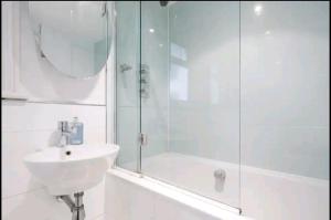 a white bathroom with a sink and a shower at Stylish room with private bath & terrace in super central Clapham Junction minutes from Victoria, Waterloo in London +21 photos