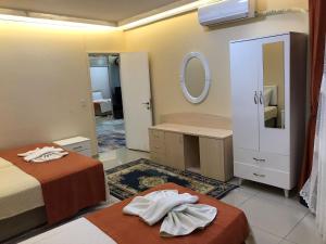 イスタンブールにあるGrand Pamir Hotelのベッド2台と鏡が備わるホテルルームです。