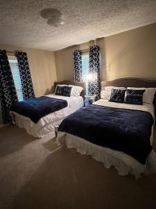 a bedroom with two beds and two windows at Luxury Lakefront property in Milledgeville