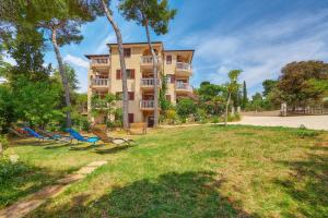 a building with chairs in front of a park at Villa Emilia in Banjole