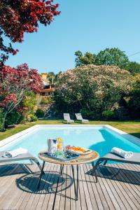 uma mesa num deque ao lado de uma piscina em The Quixote House em Caminha