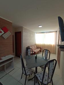 sala de estar con mesa, sillas y sofá en Lindo apartamento, pertinho do mar e com vista, en Maragogi