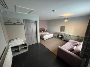 ein Schlafzimmer mit einem Bett und einem Sofa in einem Zimmer in der Unterkunft The Black Horse Inn in Gainsborough