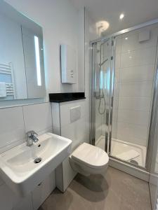 ein Bad mit einem Waschbecken, einer Dusche und einem WC in der Unterkunft Hotel Arkade in Leverkusen
