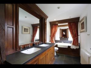 a bathroom with two sinks and a large mirror at B&B Harlington Manor in Harlington