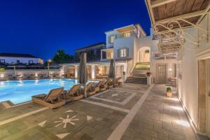 a villa with a swimming pool at night at Zoe's Club in Spetses