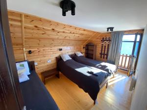 a bedroom with two beds in a room with wooden walls at Zlatar Lake Hill in Nova Varoš