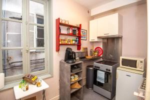 uma pequena cozinha com um fogão e uma janela em LA BELLE PIERRE - Appartement de charme très calme en Cœur de Ville em Auxerre