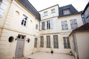 een groep witte gebouwen met een binnenplaats bij LA BELLE PIERRE - Appartement de charme très calme en Cœur de Ville in Auxerre