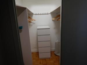 un placard avec des étagères blanches et un tiroir blanc dans l'établissement Studio Quartier Château - Wifi - Garage individuel à clé - Electroménager complet, à Pau
