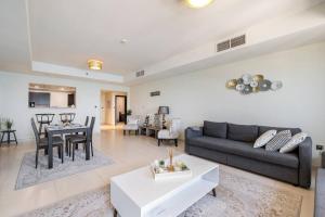 un soggiorno con un divano e un tavolo di Balqis Residense Palm Jumeirah,Pool, Beach, Top floor, Full sea view, Restaurants a Dubai