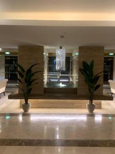 un hall avec deux plantes en pot et un lustre dans l'établissement Balqis Residense Palm Jumeirah,Pool, Beach, Top floor, Full sea view, Restaurants, à Dubaï