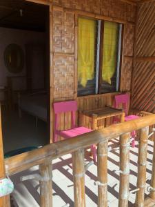 dwa krzesła i stół na ganku kabiny w obiekcie Isla Mystica Beach Resort w mieście San Juan