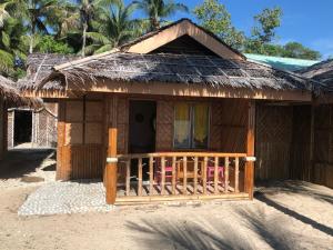 małą chatę z dachem krytym strzechą i gankiem w obiekcie Isla Mystica Beach Resort w mieście San Juan