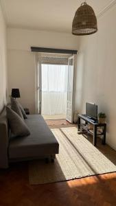 a living room with a couch and a television at Coral Apartment in Lisbon