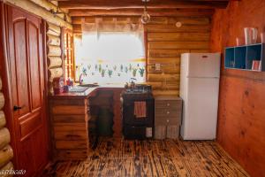 a kitchen with a refrigerator and a stove in a cabin at Rincón Lejano in Potrerillos
